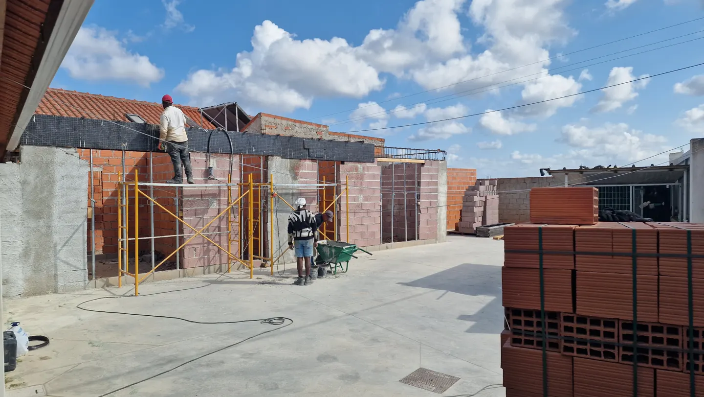 Paredes de tijolo e pilares de betão em construção.